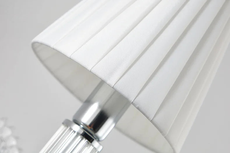 Close-up of a white lampshade with a metallic base on a light gray background