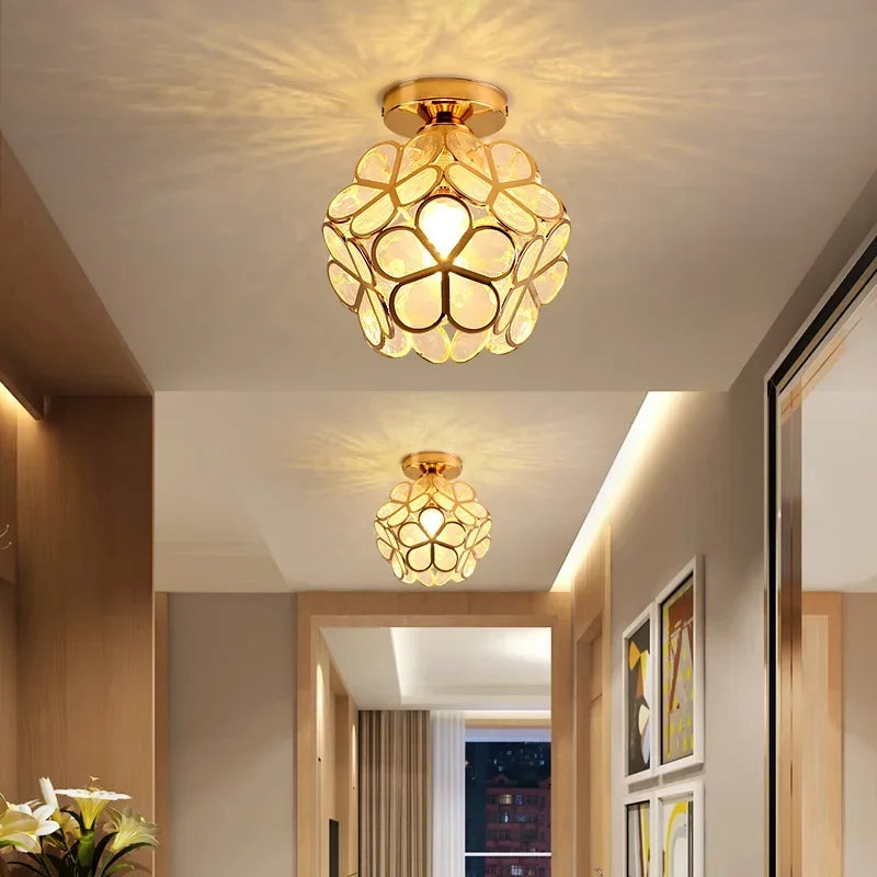 A hallway featuring two gold flush mount ceiling lights with acrylic petals casting light patterns on the ceiling.