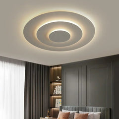 Interior shot of a bedroom showcasing the modern flush mount ceiling light installed on a white ceiling, providing ambient lighting.