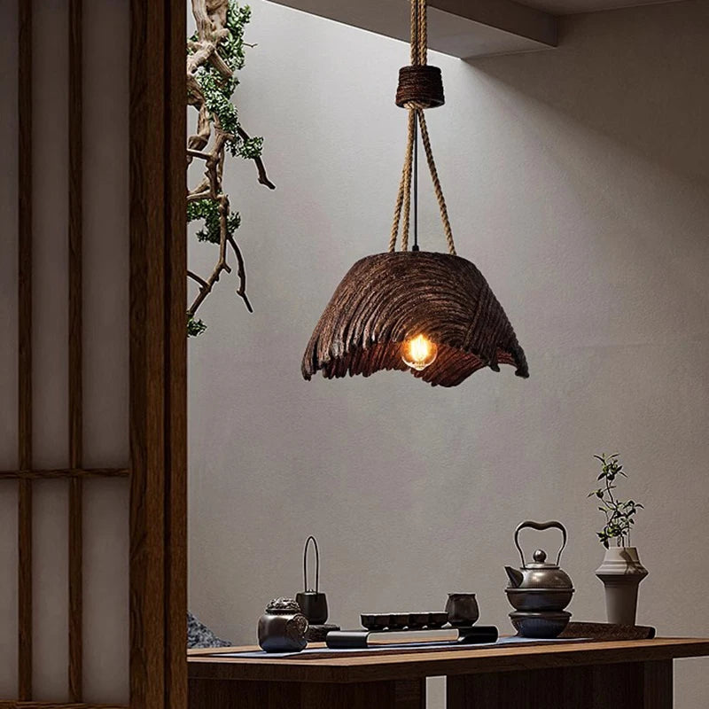 Wooden pendant light hanging in a room with a table and decorative items.