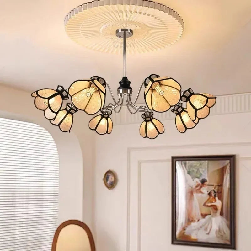 A polished chrome chandelier with eight light beige, petal-shaped shades in a circular arrangement.