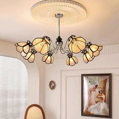 A polished chrome chandelier with eight light beige, petal-shaped shades in a circular arrangement.