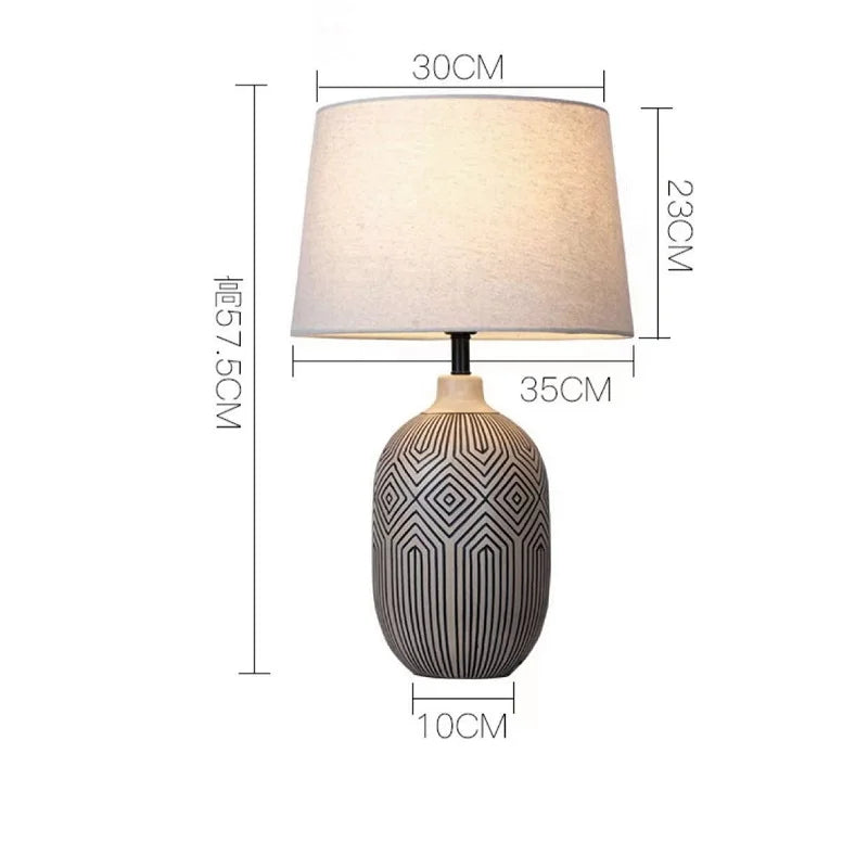 Table lamp with geometric design on base and plain lampshade, shown with dimensions.
