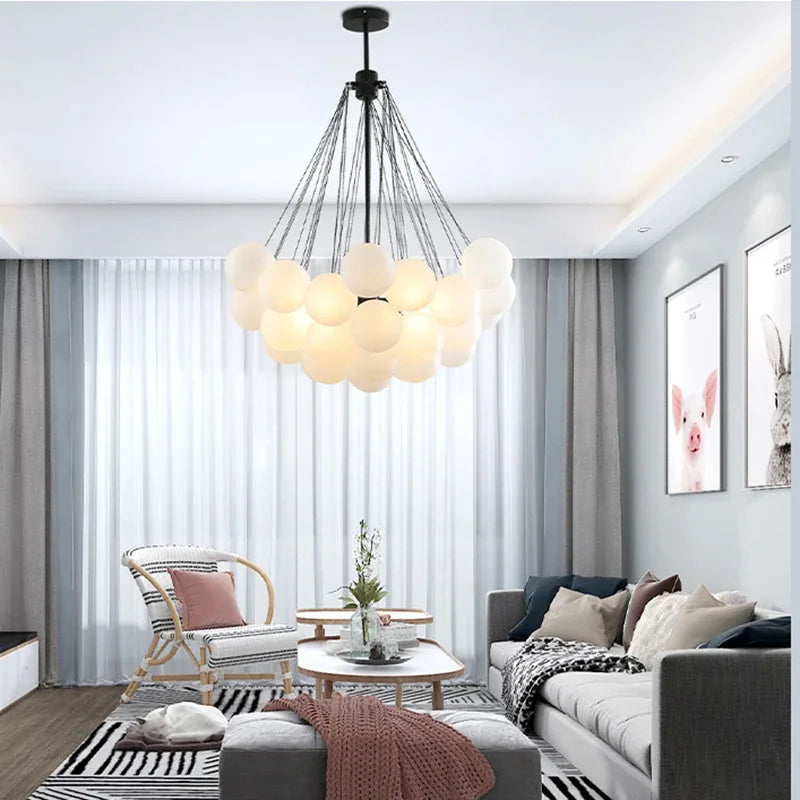 Modern living room with a chandelier, sofa, and armchair.