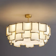Close-up view of the stacked square frosted glass shades and gold frame of a tiered pendant light.