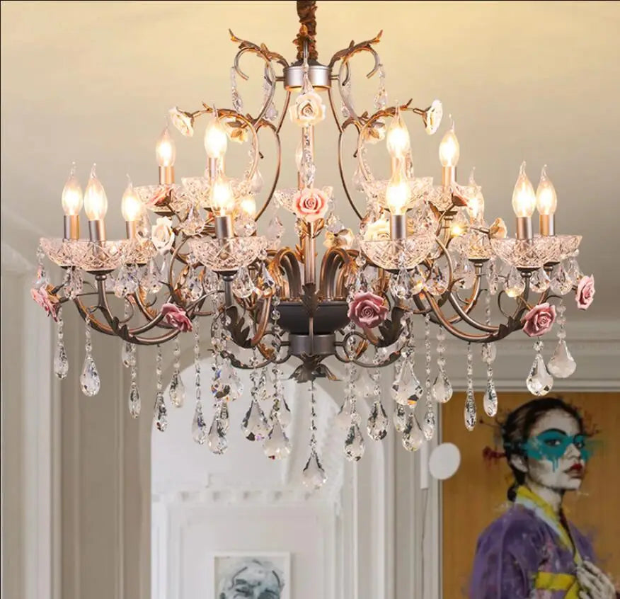A wide shot showcasing the gold floral chandelier hanging centrally in a well-lit room, with subtle hints of artwork and decor in the background.