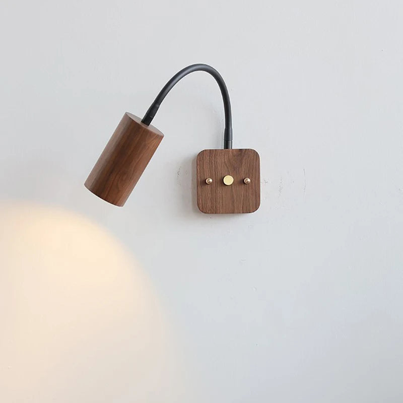 Wooden wall lamp with a flexible arm on a light gray background