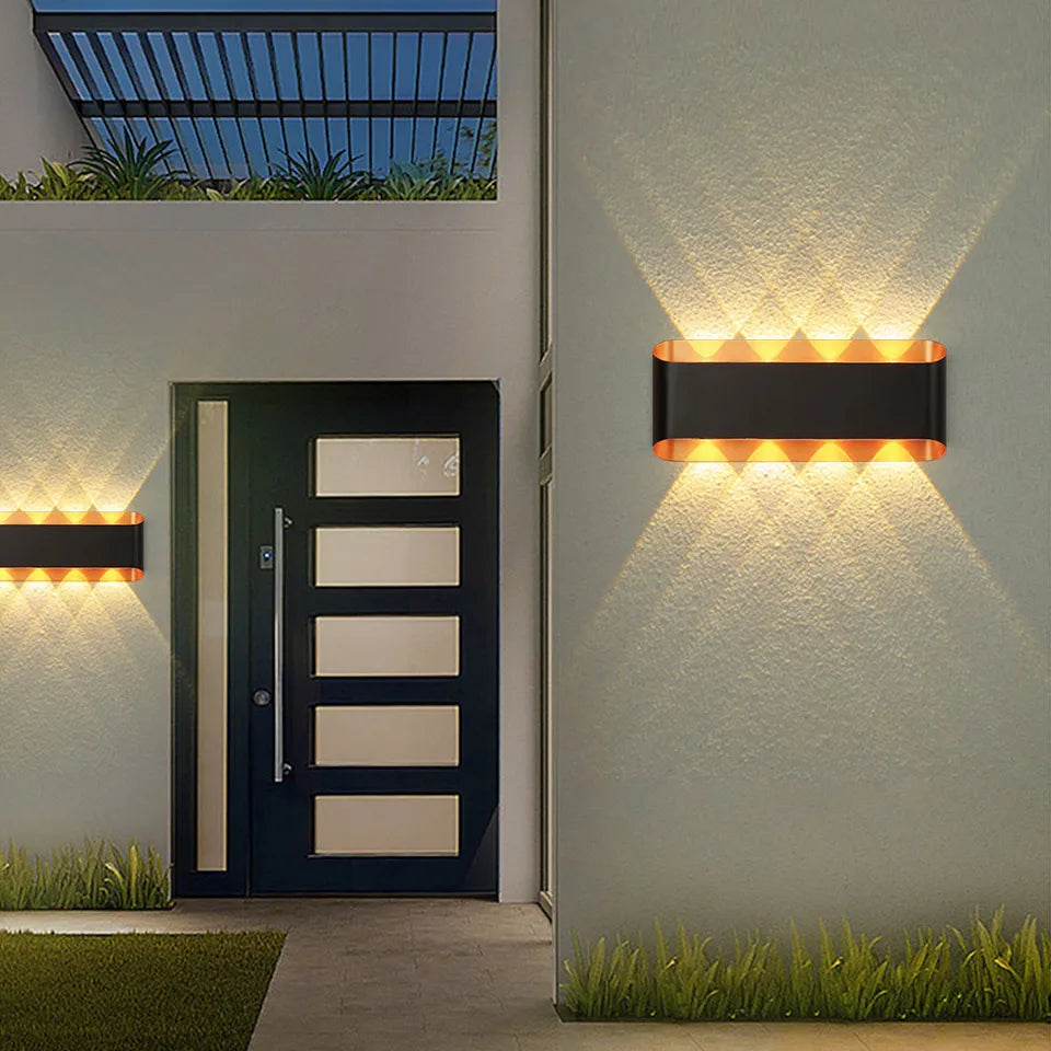 “Modern black aluminium LED wall lamp casting up and down light beside a front door.”