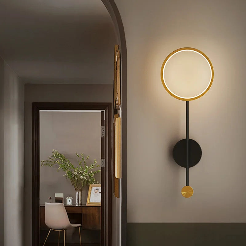 Modern wall lamp with circular design on a neutral wall.