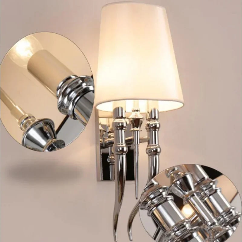 Chrome wall sconce with a white lampshade on a neutral background
