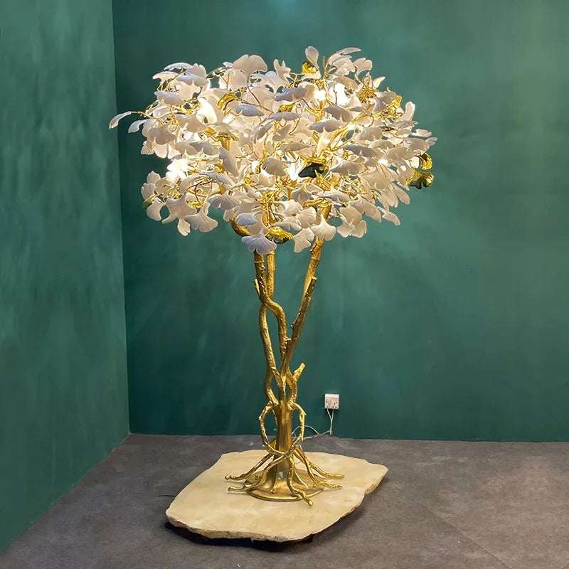 “Large statement lamp with white ceramic leaves and gold base”