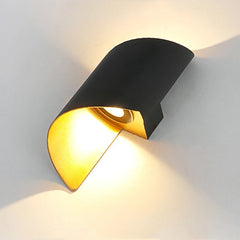 “Curved black and gold LED wall lamp casting warm up-and-down lighting.”