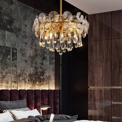 Luxury chandelier hanging in a room with a dark wall and purple headboard.