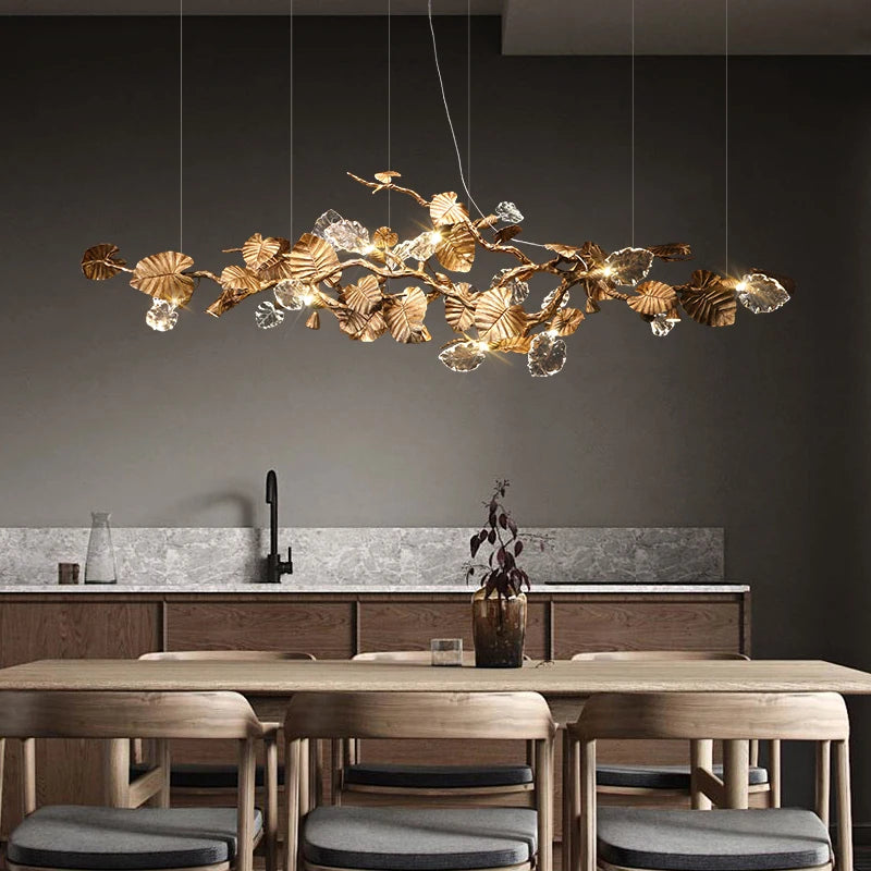 Copper branch chandelier with leaf detailing suspended above dining table
