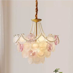 Decorative chandelier with shell-like design on a plain background