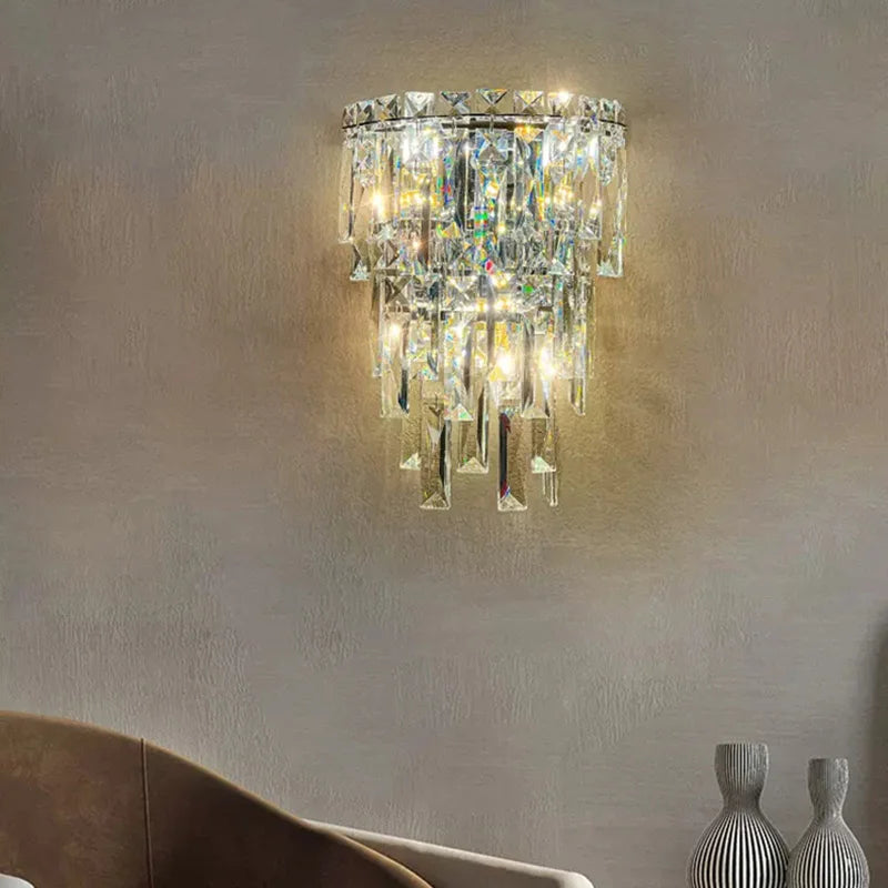Crystal wall sconce on a neutral wall with decorative vases in the foreground