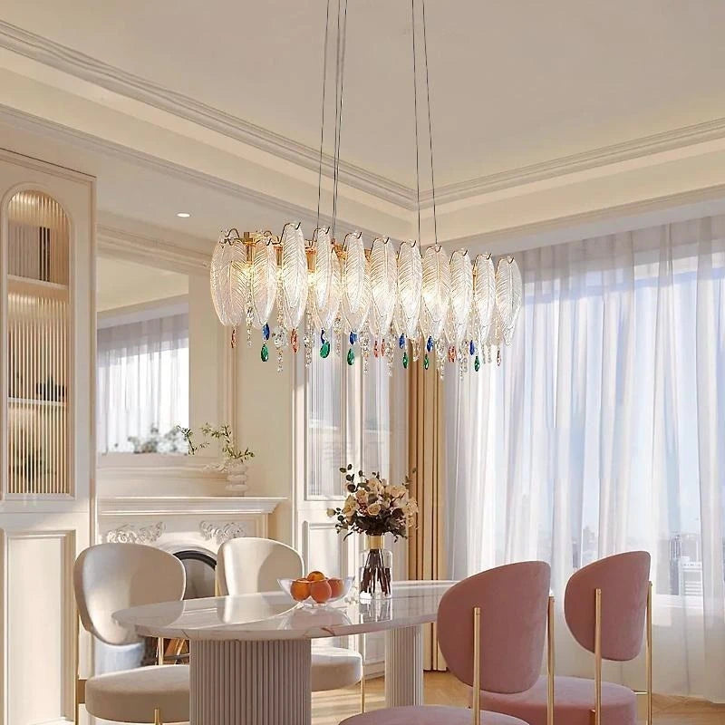 Modern dining room with a stylish chandelier, table, and chairs.