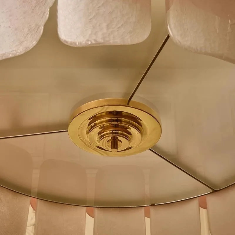 Close-up of a ceiling fan with gold metallic blades and light fixture.