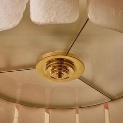 Close-up of a ceiling fan with gold metallic blades and light fixture.