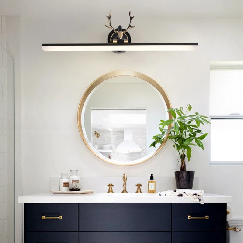 Bathroom vanity with round mirror, plant, and decorative items.