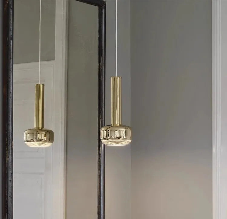 Stylish gold metal pendant light installed above a luxury bar area