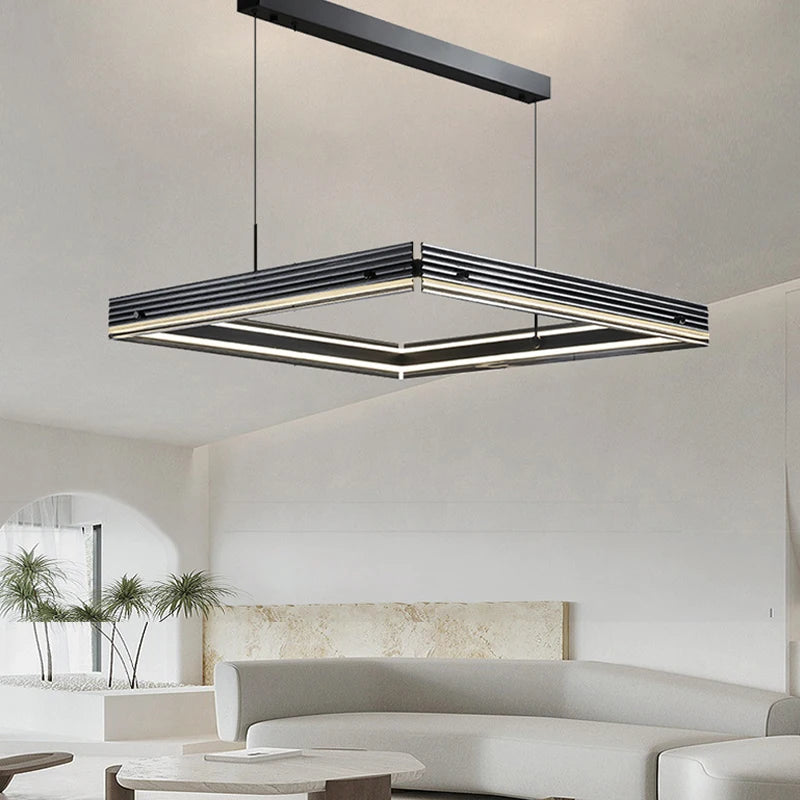 Modern square pendant light hanging in a living room with neutral decor.