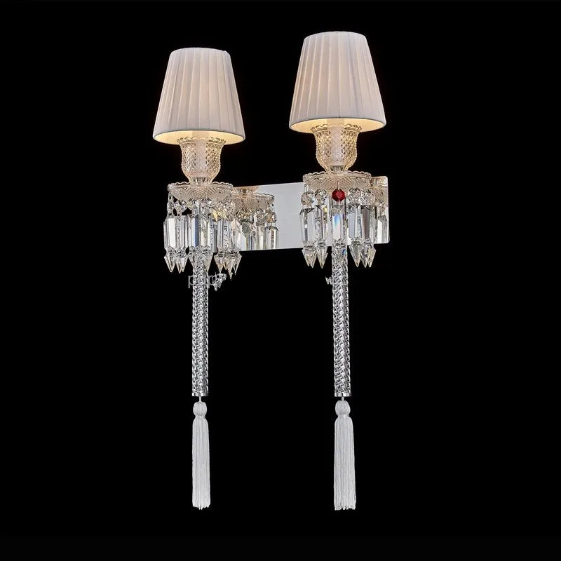 Decorative wall sconces with crystal details and white lampshades on a black background