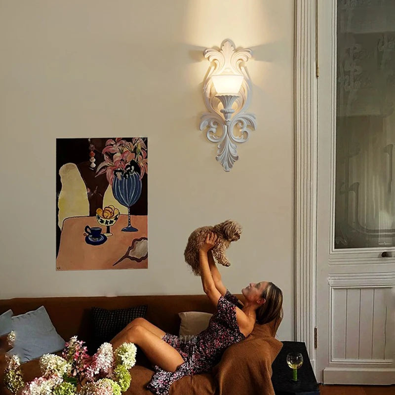 Woman playing with a dog in a living room with a painting on the wall.
