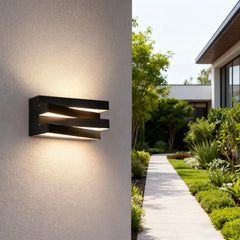 “Layered outdoor wall light illuminating a white contemporary home facade.”
