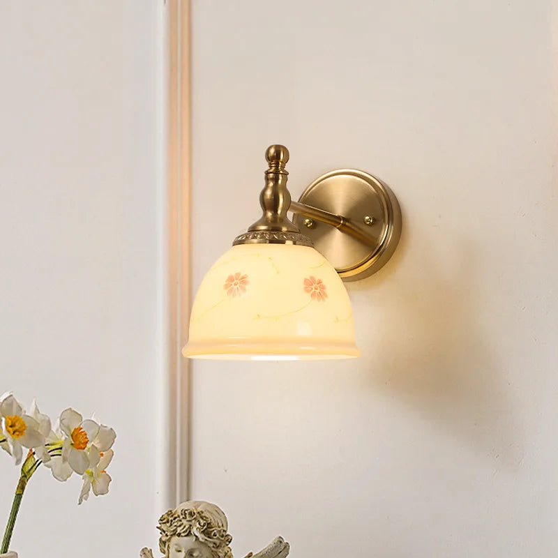 Wall-mounted lamp with decorative glass shade on a light wall.