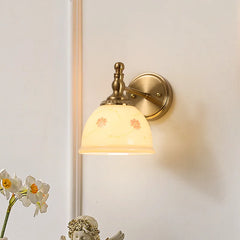 Wall-mounted lamp with decorative glass shade on a light wall.