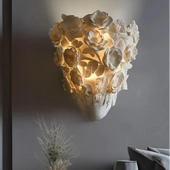 Decorative wall sconce with floral design on a gray wall, featuring the No.7 Lighting logo.