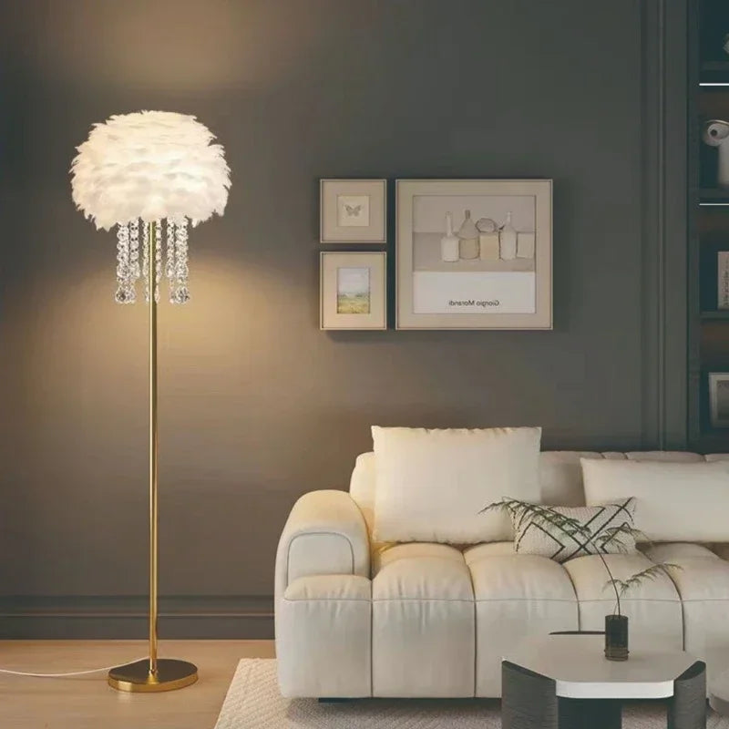 Liglite gold floor lamp with soft feather shade for cozy interiors. Modern living room with a floor lamp, sofa, and wall art.