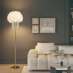 Liglite gold floor lamp with soft feather shade for cozy interiors. Modern living room with a floor lamp, sofa, and wall art.