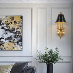 Decorative wall sconce with a black and gold finish in a stylish interior setting.
