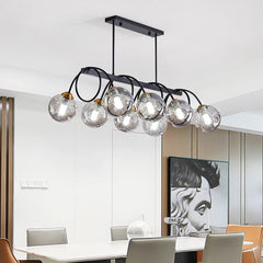 “Linear ceiling chandelier with multiple glass globes and warm ambient glow.”