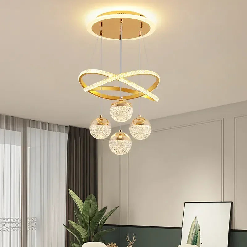 Modern ceiling light fixture with gold rings and crystal balls in a room setting.