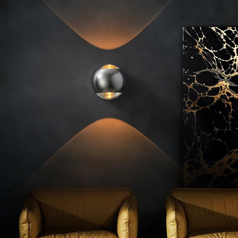 Modern wall sconce on a dark wall with two armchairs and a marble-patterned painting.