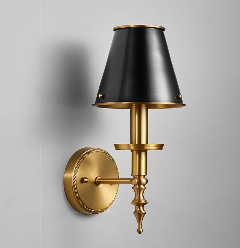 Wall-mounted lamp with black shade and gold fixture on a gray background