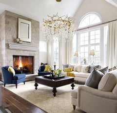 Living room with fireplace, chandelier, and comfortable seating. Branch-shaped copper and crystal grand chandelier for living or hotel