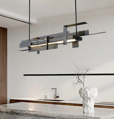 Modern pendant chandelier above a long marble dining table

