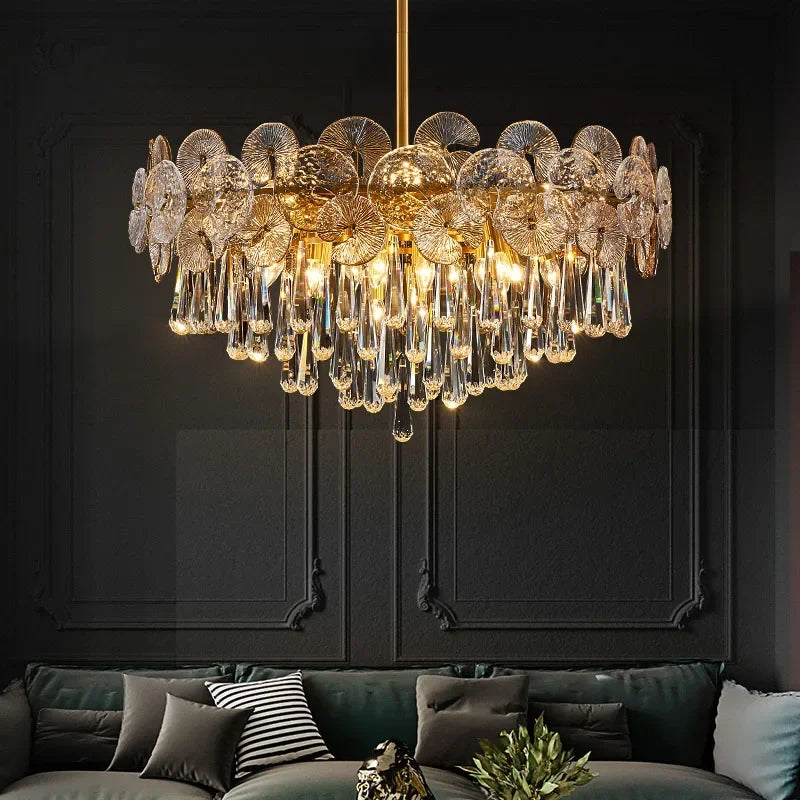 Luxurious chandelier hanging above a sofa with dark walls in the background