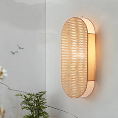 Wall-mounted light fixture with woven design on a neutral wall.
