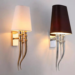 Two wall sconces with decorative legs on a plain background