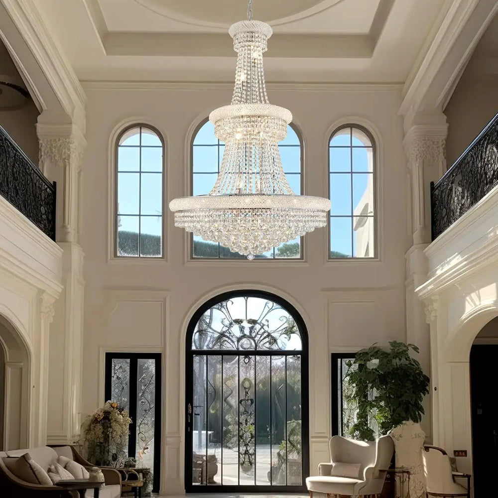 Modern empire-style crystal chandelier installed in a high-ceiling entryway