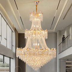 Luxurious chandelier hanging in a modern indoor setting with large windows.