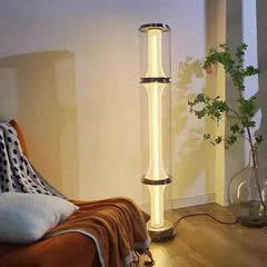 “Modern cylindrical glass floor lamp with brushed nickel accents”