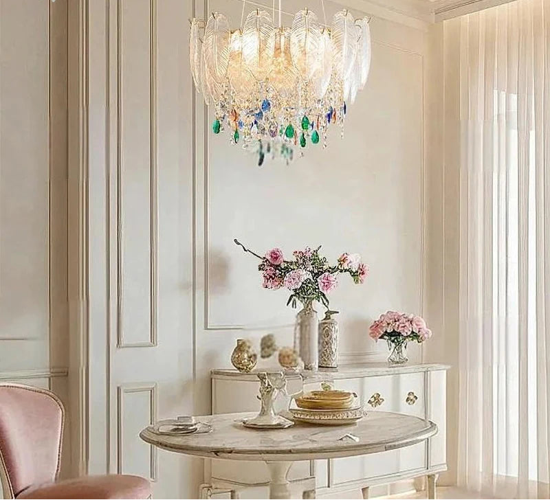 Decorative chandelier hanging above a table with floral arrangements in a stylish room.
