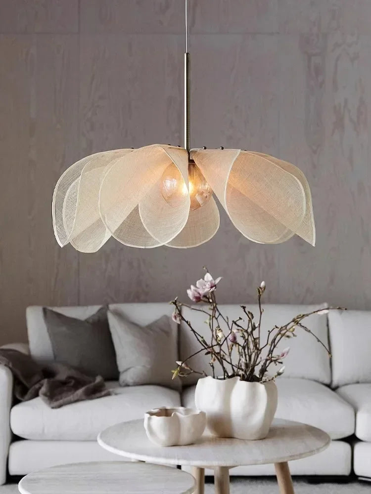 Modern pendant light fixture in a living room setting with a neutral colour palette. Modern Japandi-inspired fabric flower chandelier for the living room.
