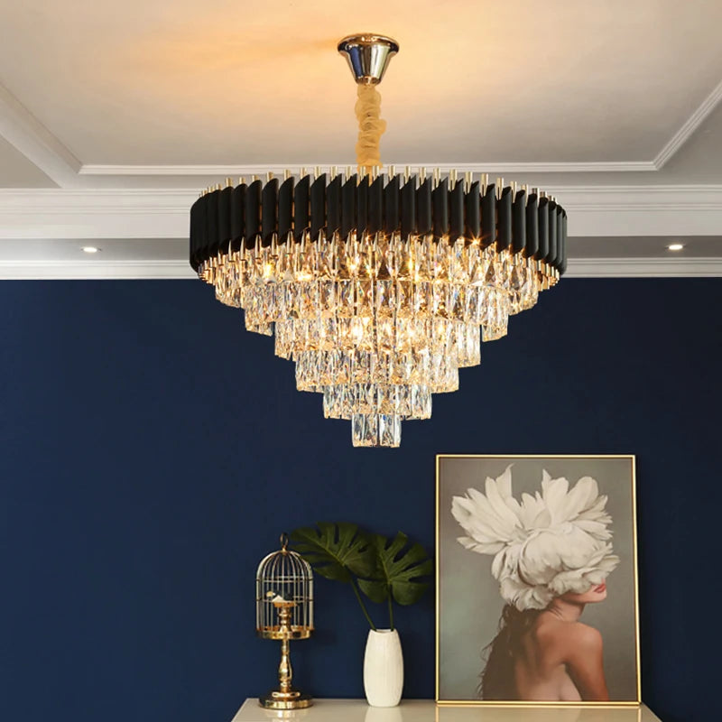 Chandelier hanging in a room with a blue wall, small table with decorative items, and a framed picture.